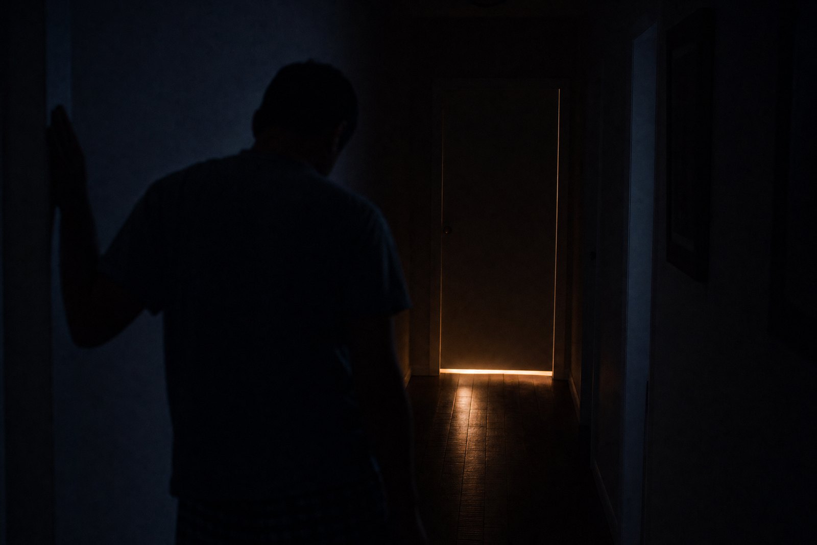 Pasillo a oscuras de noche con la luz del baño prendida: los despertares nocturnos por la próstata